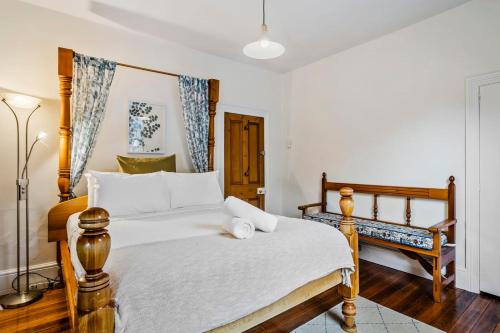 Un dormitorio con una cama grande con marco de madera. en Karkalla Terrace - Explore Hobart's Historic Heart, en Sandy Bay