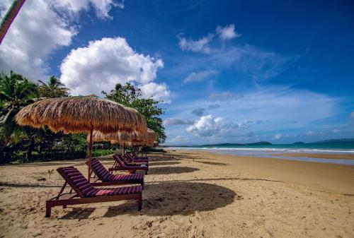 a group of chairs under an umbrella on a beach at Club Agutaya in San Vicente