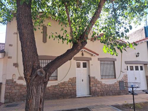 a house with a tree in front of it at Habitaciones en Casa Típica Mendocina in Mendoza