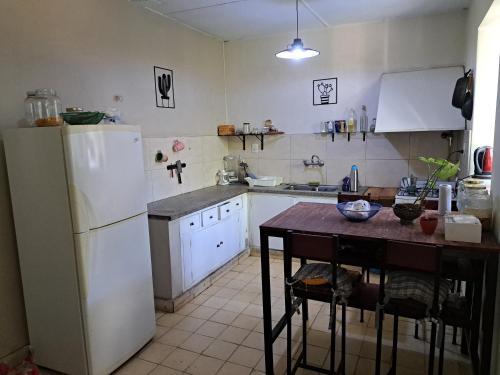 a kitchen with a white refrigerator and a table at Habitaciones en Casa Típica Mendocina in Mendoza