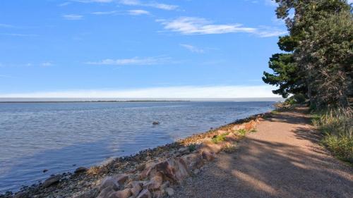a path next to a large body of water at Lake Metung in Metung