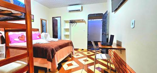 Hotel Cida Flats - Apartamento Charmoso com 300 Mbps في بوا فيستا: غرفة نوم مع سرير بطابقين ومكتب مع جهاز كمبيوتر