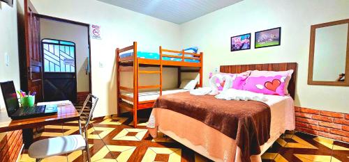 - une chambre avec des lits superposés et un bureau dans l'établissement Hotel Cida Flats - Apartamento Charmoso com 300 Mbps, à Boa Vista