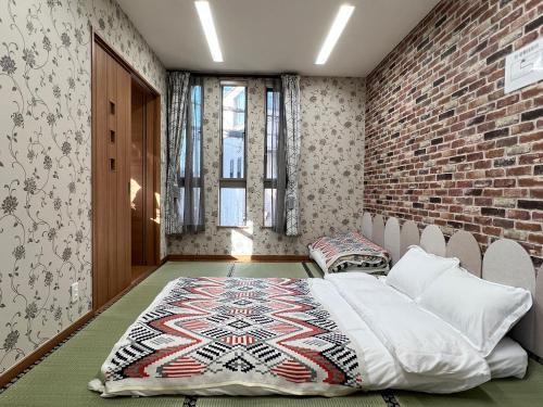 a bedroom with a bed and a brick wall at 鹤桥站3线热门大站独栋别墅3卧室双卫心斋桥日本桥2站道顿堀3站难波3站梅田Usj神户京都奈良一线直达 in Osaka