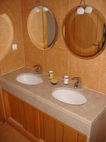 a bathroom with two sinks and two mirrors at Villa Casa Dina in Casal da Lagoa Seca
