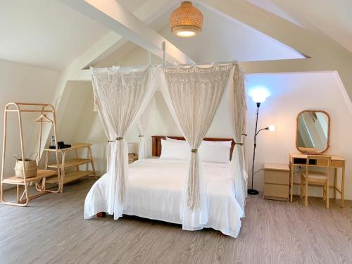 1 dormitorio con 1 cama blanca con dosel en 綠意山莊 Greenforest, en Yuanli