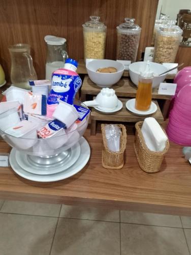 un tavolo con ciotole di cibo e bevande di Hotel Canto do Atlântico a Guarujá