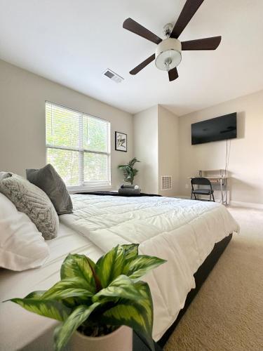 1 dormitorio con 1 cama grande y ventilador de techo en Uptown CLT - Modern Townhouse, en Charlotte