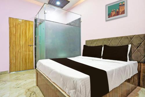 1 dormitorio con 1 cama grande y puerta de cristal en OYO The Orchid Hotel, en Nagpur