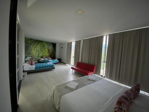 a bedroom with a bed and a living room at La Traviata Hotel in Santa Rosa de Cabal