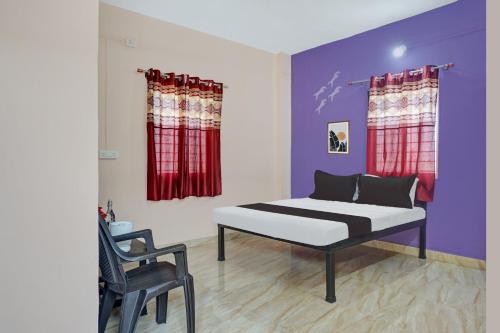 1 dormitorio con 1 cama y 1 silla en OYO Sky 7 Lodge, en Pune