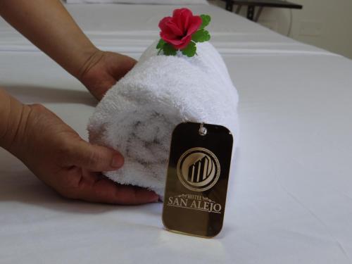 a person holding a towel with a flower on it at San Alejo in Tuluá