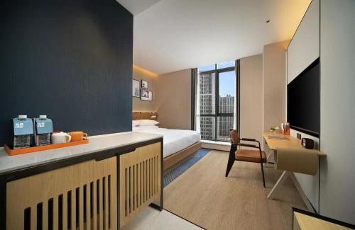 a hotel room with a bed and a desk with a television at Four Points by Sheraton Chengdu, High-Tech Zone Exhibition Center in Chengdu