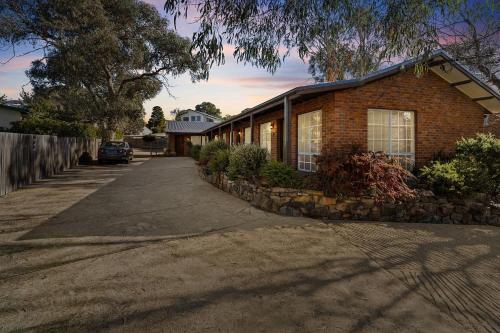 a brick house with a driveway in front of it at Sponars Onshore - 2BR Apartment l Pet-Friendly l WiFi l Air-Con l Fenced Backyard in Jindabyne