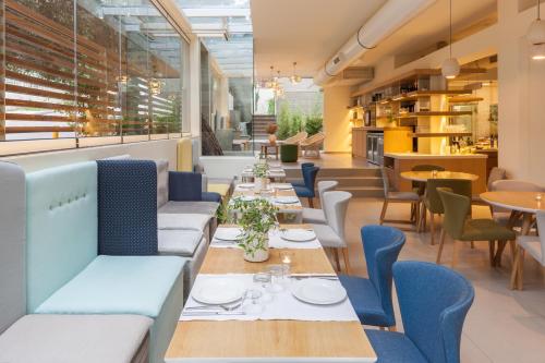 uma sala de jantar com mesas e cadeiras e uma cafetaria em Coco-Mat Hotel Nafsika em Atenas