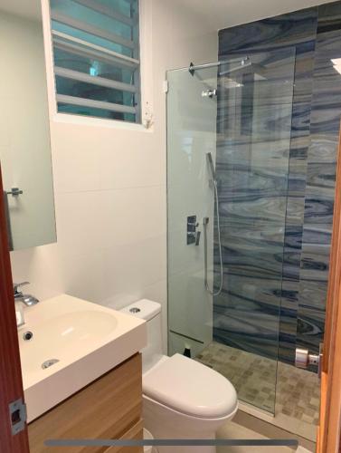 a bathroom with a toilet and a glass shower at Villa Brisas del Mar-Ocean View, Gated Community in Dorado