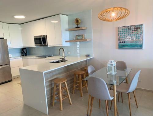 a kitchen with a counter and a table and chairs at Villa Brisas del Mar-Ocean View, Gated Community in Dorado