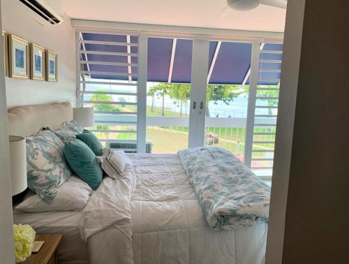 a bedroom with a bed and a large window at Villa Brisas del Mar-Ocean View, Gated Community in Dorado