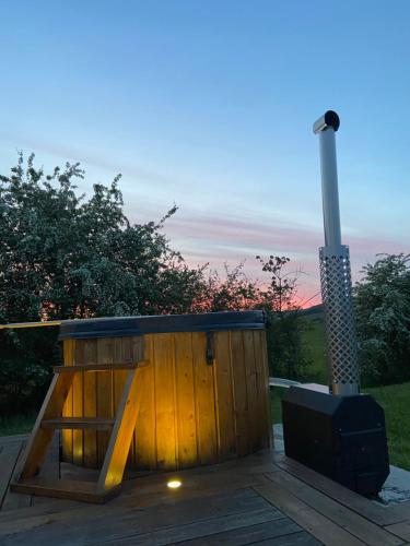 une boîte en bois avec un poêle sur une terrasse dans l'établissement Nuit insolite en Tipi avec bain nordique privatif, petits déjeuners inclus, à Médonville