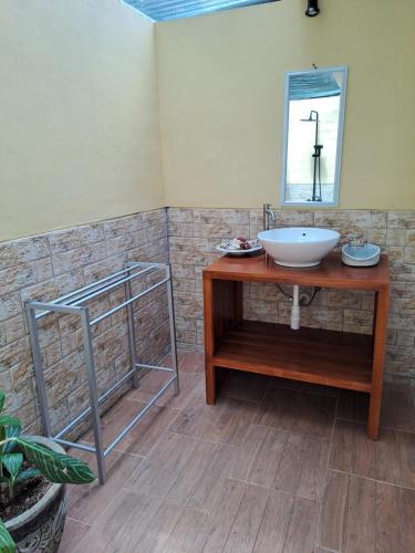 La salle de bains est pourvue d'un lavabo et d'un miroir. dans l'établissement The Palms Penida, à Toyapakeh