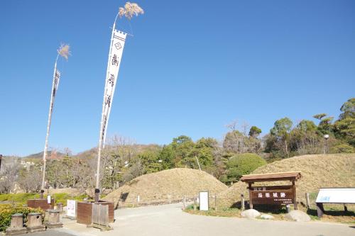 a totem pole in a park with hay stacks at REF Matsuyama City Station by VESSEL HOTELS in Matsuyama