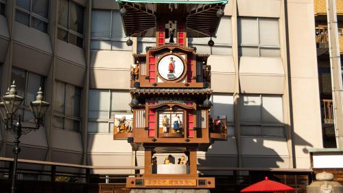a clock tower in front of a building at REF Matsuyama City Station by VESSEL HOTELS in Matsuyama