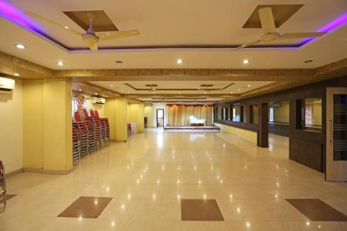 um grande salão com uma pista de dança com luzes roxas em OYO Flagship Hotel DS Grand Inn em Lingampalli