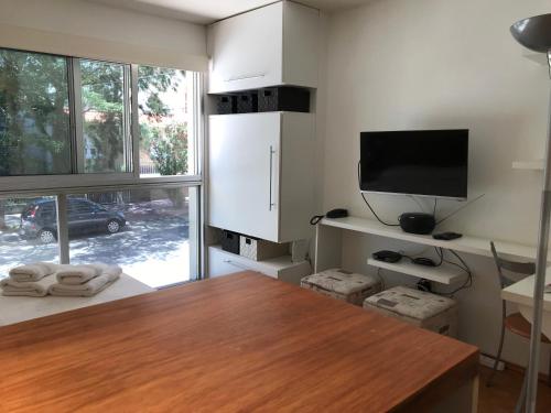 uma sala de estar com uma mesa e uma televisão em Monoambiente En Arturo Prat em Montevidéu