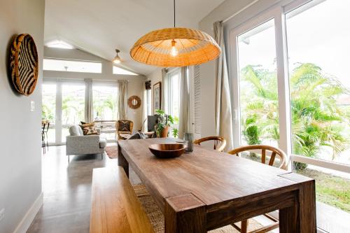 a dining room with a wooden table and a large window at Villa Sueño Azul - Blue Venao 3BR in Playa Venao
