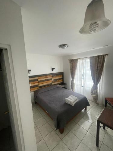 um quarto com uma cama e uma grande janela em Kunturi Guest House em Arica
