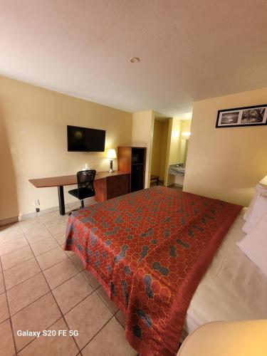 a hotel room with a bed and a desk at La Vista Motel in Brownsville