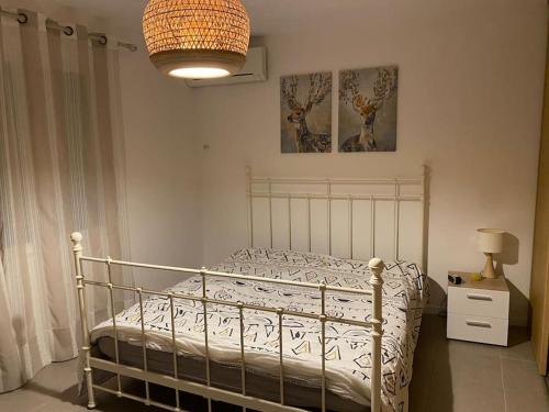 - une chambre avec un lit, une lampe et un lustre dans l'établissement Grande maison luxe avec piscine, à Mandelieu-la-Napoule