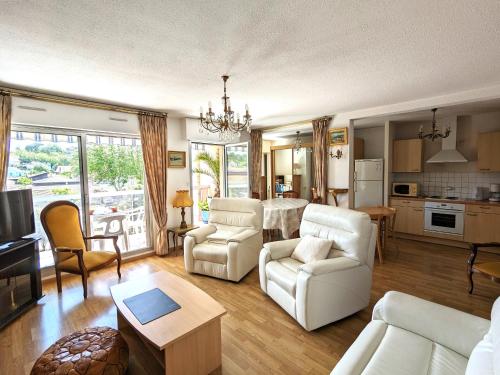 Il comprend un salon avec un mobilier blanc et une cuisine. dans l'établissement Lumineux T3 avec Balcons et Parking - Centre Arcachon, Résidence Magellan, Proche Plage & Commerces - FR-1-420-149, à Arcachon