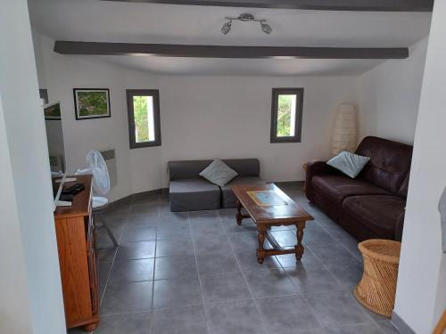 un salon avec un canapé et une table dans l'établissement Villa au Calme avec Jardin, Proche Plage, Équipée pour Familles - FR-1-194-285, à La Faute-sur-Mer