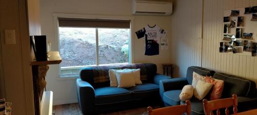 a living room with a blue couch and a window at Avalon Blue @ Derby - *Blue Derby Endorsed* in Derby