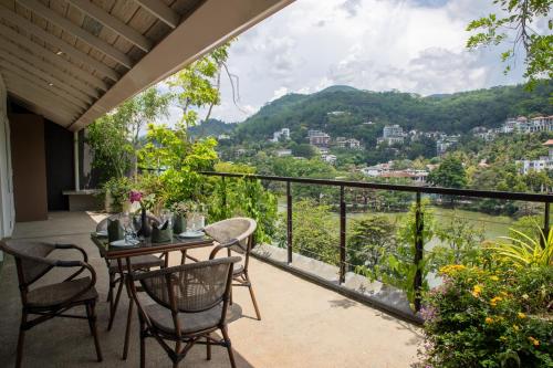 einen Balkon mit einem Tisch und Stühlen sowie Aussicht in der Unterkunft Lake Avenue Hotel Kandy in Kandy