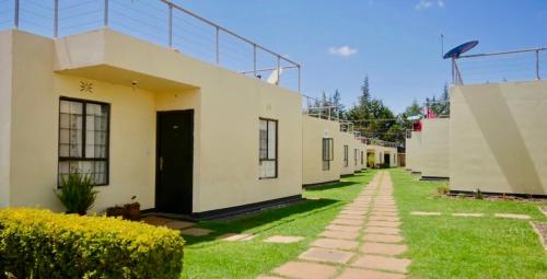 eine Reihe von Häusern mit einem Rasenplatz neben einem Gebäude in der Unterkunft Unity homes #G08 in Eldoret
