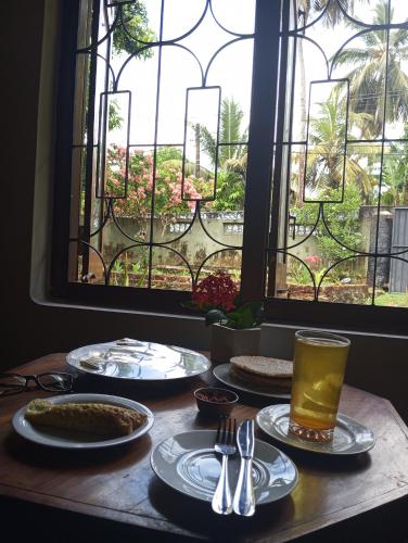 a table with plates of food and a window at Dishari Tangalle in Tangalle