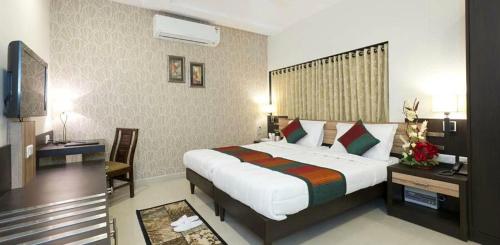 Habitación de hotel con cama grande y TV en Hotel Siddharth palace en Jaipur