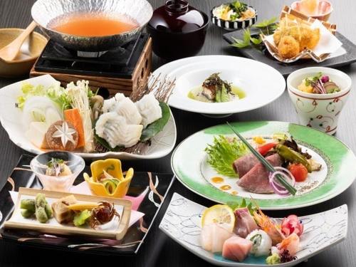 a table with plates of food and a bowl of soup at Kyukamura Takeno-Kaigan in Toyooka