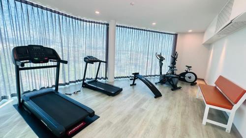 a gym with two treadmills and two exercise bikes at Poolrada Boutique Hotel - SHA Plus in Thalang