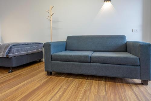 a blue couch and a bed in a living room at Coast Inn Motel in Ballina