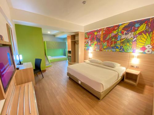una camera da letto con un letto e un dipinto sul muro di MAXONE Dumai a Dumai