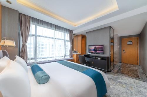 a hotel room with a large bed and a television at Sun Garden Hotel in Shenzhen