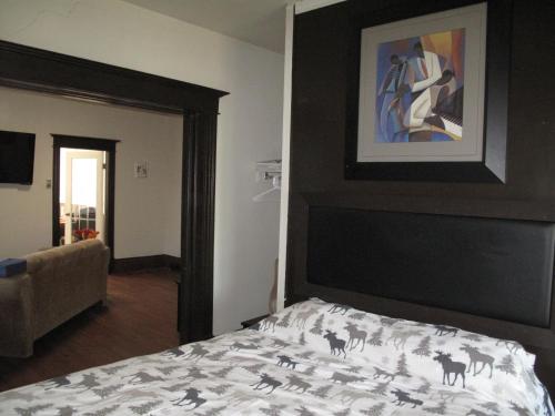 1 dormitorio con 1 cama con una pintura en la pared en Wolseley the heart of the city ! en Winnipeg