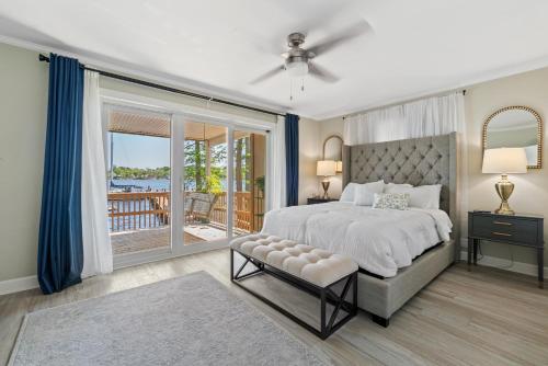 a bedroom with a large bed and a balcony at Water Front Condo with Boat Slip: The Dock House in Elizabeth City