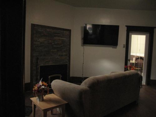 sala de estar con sofá y chimenea en Wolseley the heart of the city !, en Winnipeg