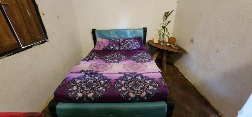 a colorful bed sitting in a corner of a room at LA PIRATA Casa Hostel in Palomino