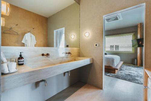 uma casa de banho com um lavatório e um espelho grande em อาทิตย์ รีสอร์ท เกาะล้าน em Ko Larn