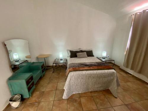 1 dormitorio con 1 cama, 2 mesas y 2 lámparas en Casa las Trojes en Aguascalientes